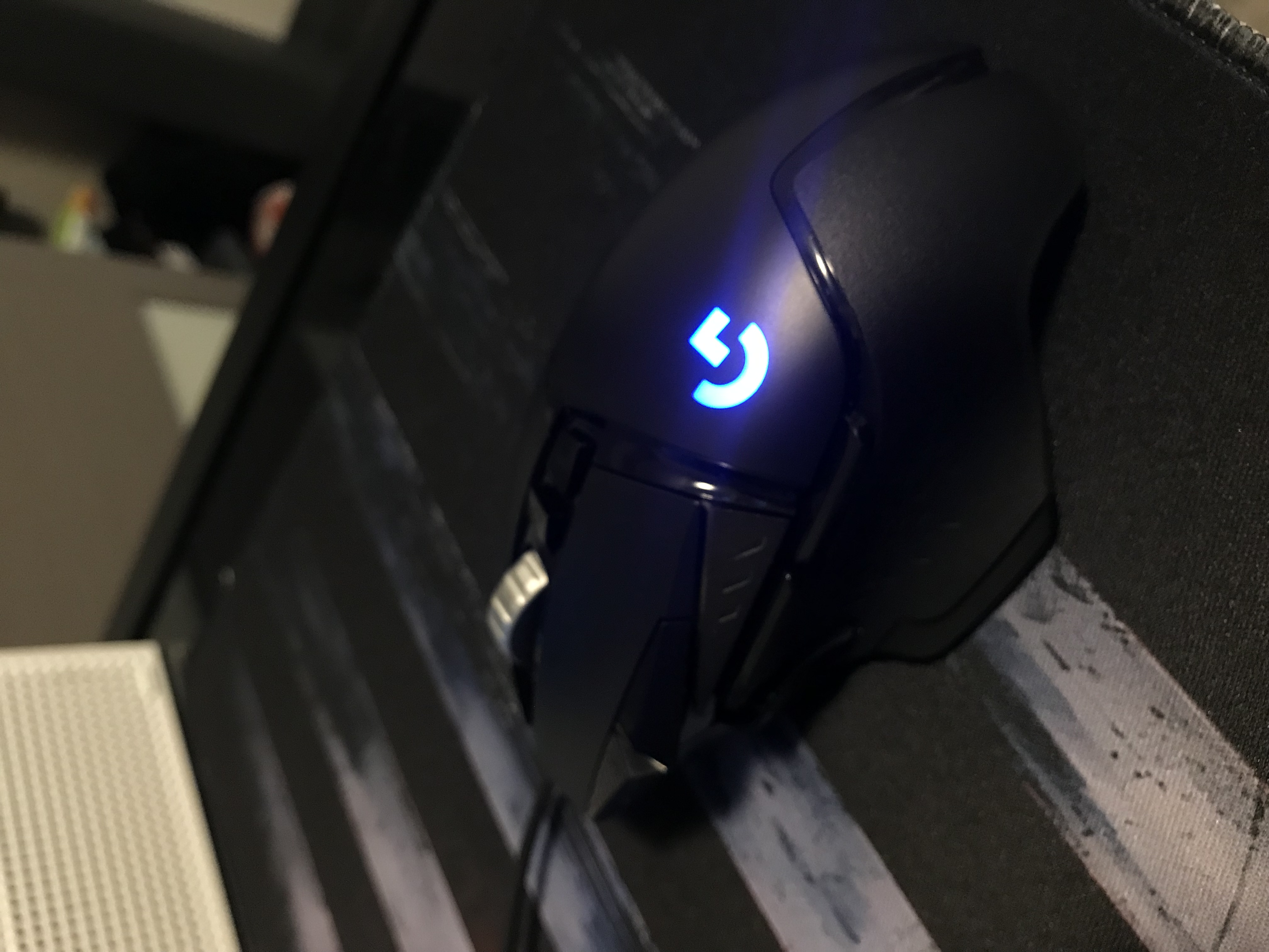 有線G502 HEROの実機を机の上に置いた写真。ケーブルと青いロゴ照明が見える