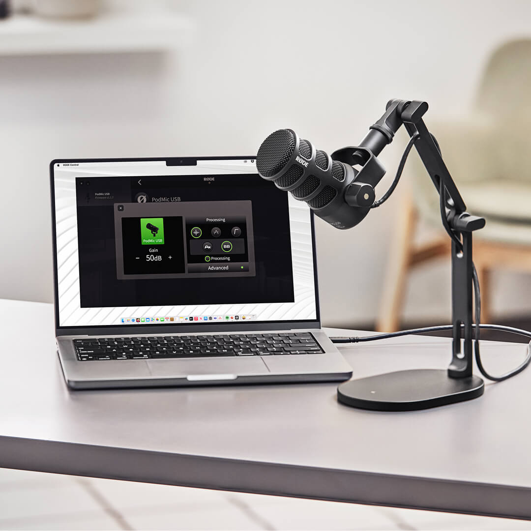 黒いPodMic USBを卓上アームに取り付け、ノートPCの横で使う公式写真
