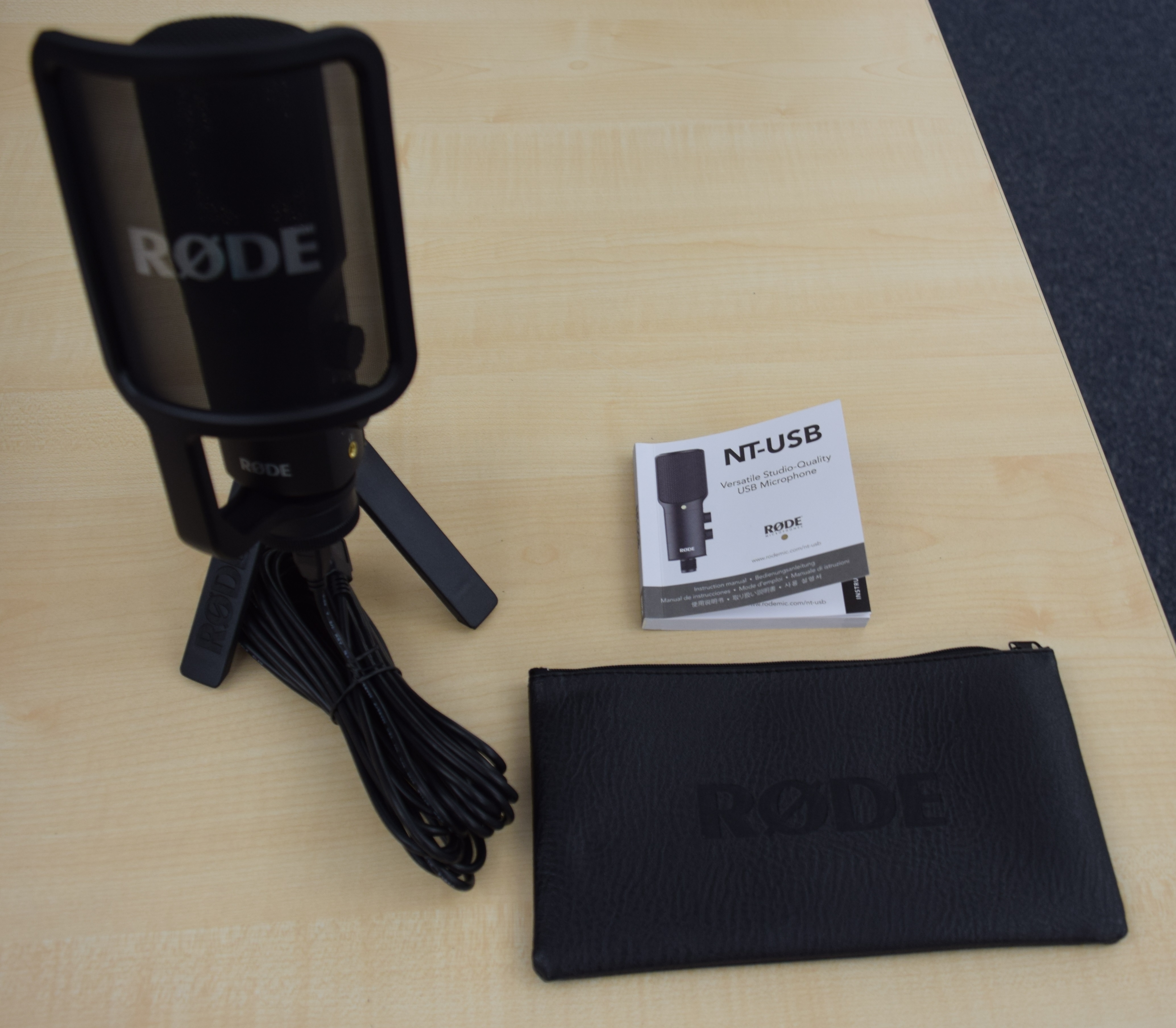 RØDE NT-USB旧型のマイク、三脚、ケーブル、説明書、ポーチを並べた実物写真