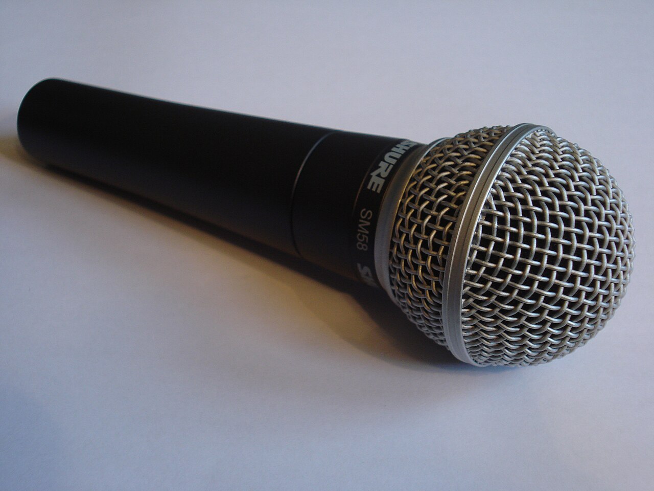 Shure SM58有線マイクの実機を斜めから写した写真。球形グリルと胴体が見える
