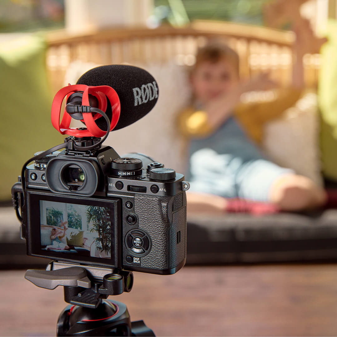 三脚上のカメラとマイクを、ソファの話者へ向けたメーカーの使用例。 写真：RØDE。